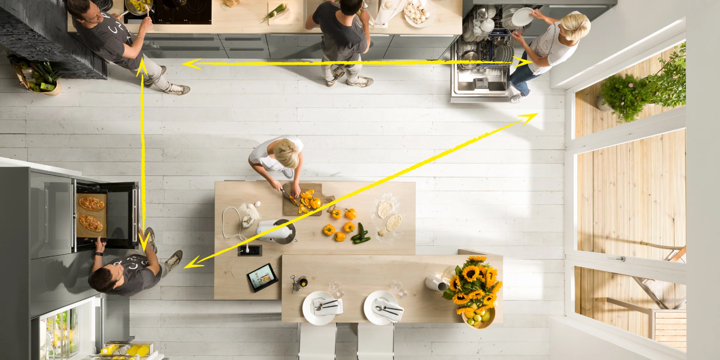 Eine moderne Küche mit Personen beim Kochen, ausgestattet von Nolte Küchen.