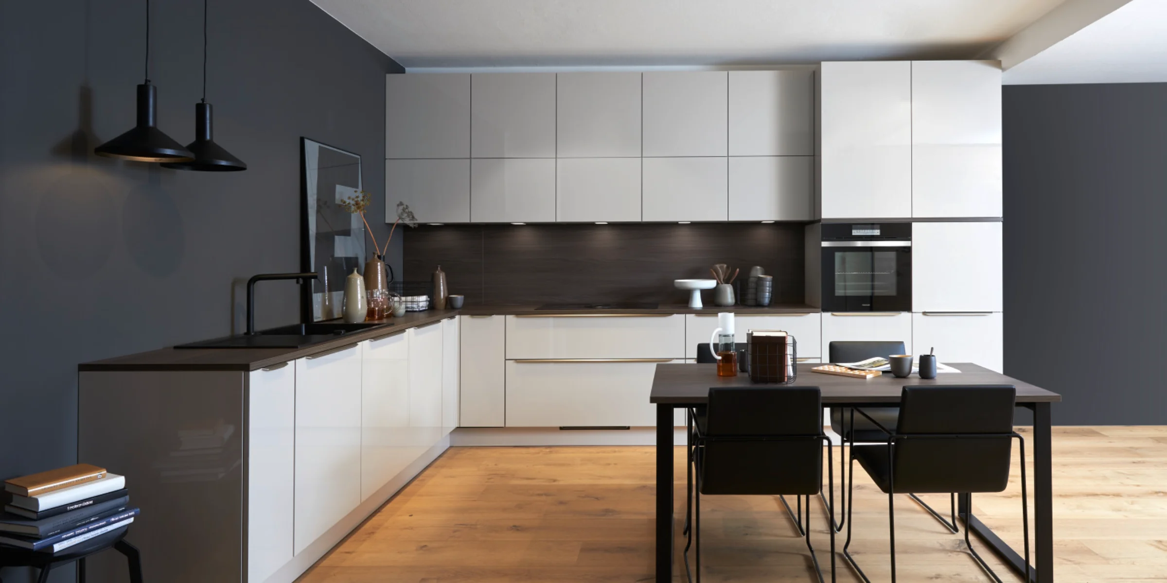 Eine moderne Küche mit weißen Schränken und Esstisch, gestaltet von Nolte Küchen.