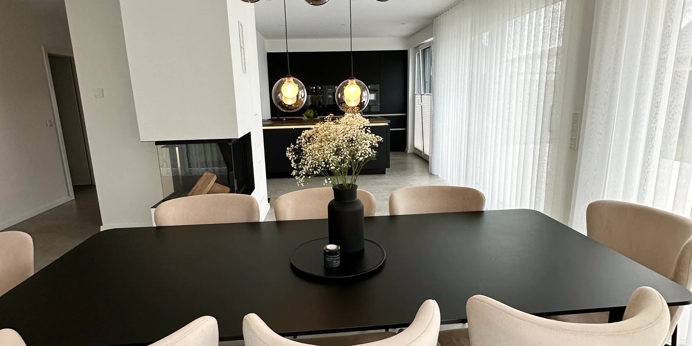 Ein elegantes Esszimmer mit modernem Tisch und Stühlen, betont durch stilvolle Beleuchtung, von Nolte Living.