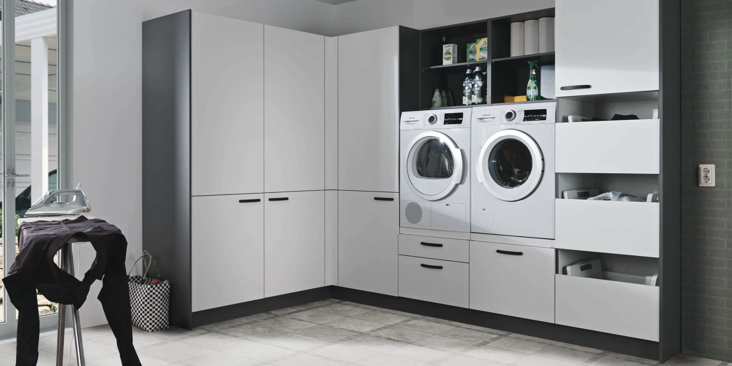 Ein Hauswirtschaftsraum mit Waschmaschine und Trockner in modernen Schränken. Express Hauswirtschaftsräume.