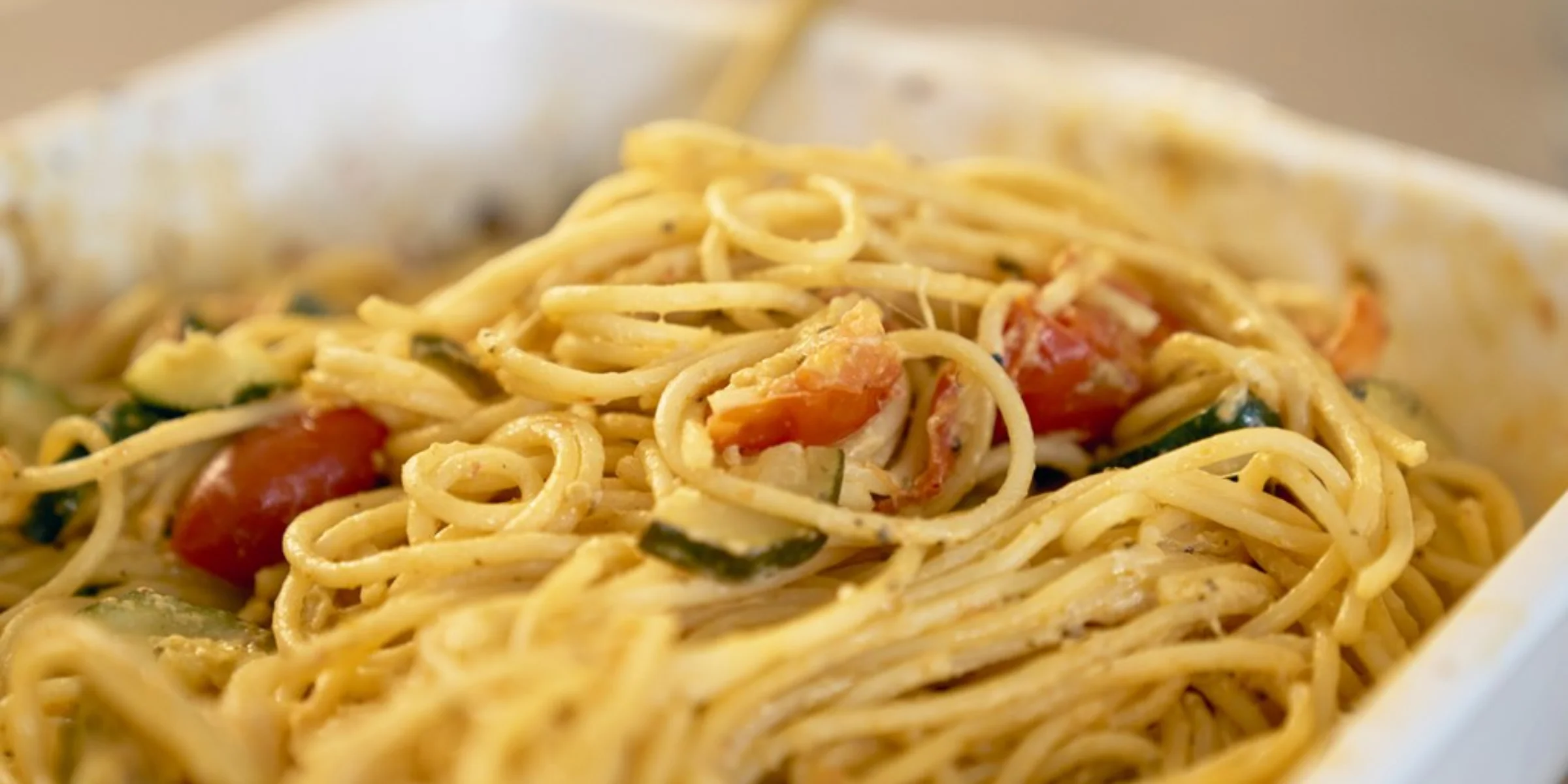Ein Teller mit Spaghetti und Tomaten in einer modernen Umgebung von Nolte Küchen.