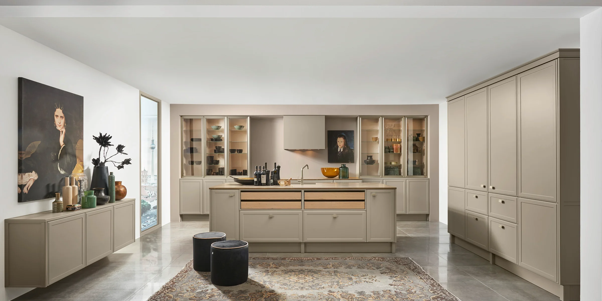 Una cocina moderna y elegante con isla central y armarios beige, diseñada por Nolte Cocina.