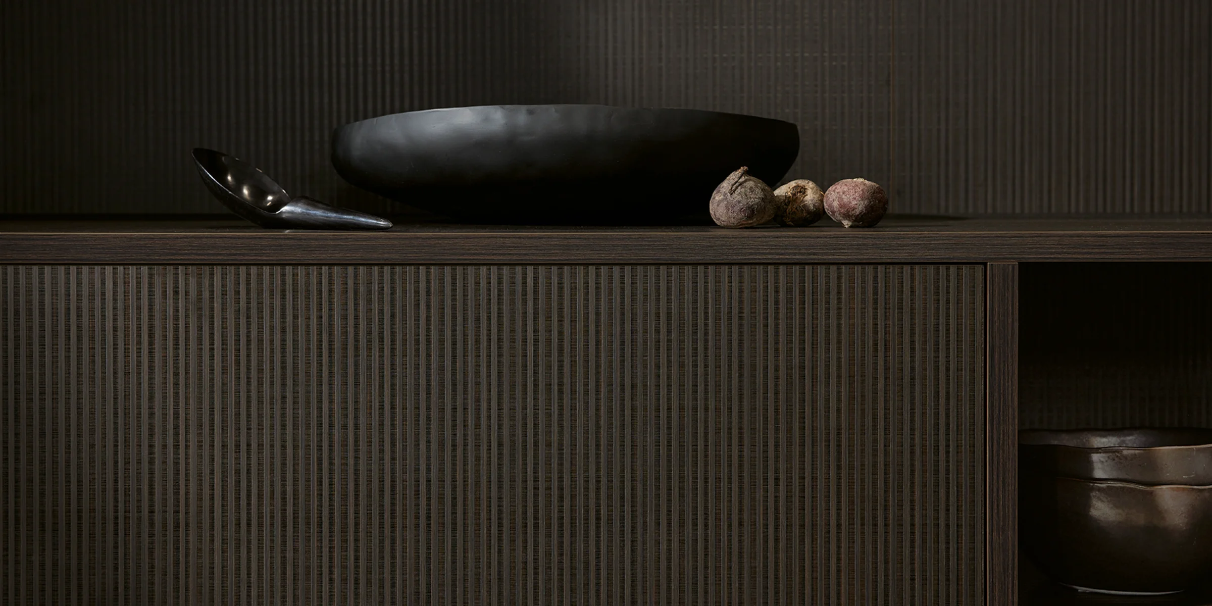 Elegantes Küchendesign mit dunklen Oberflächen und Dekorationen, präsentiert von Nolte Küchen.