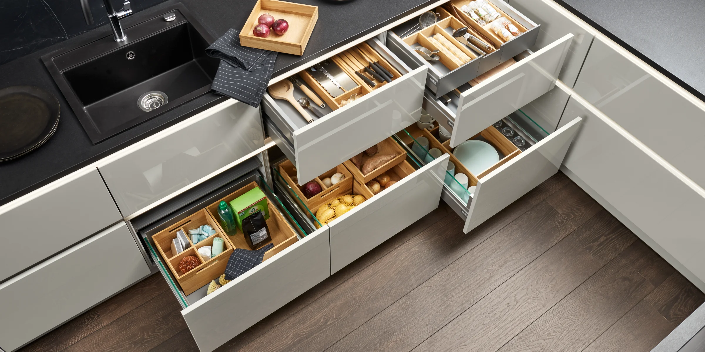 Eine moderne Küche mit geöffneten Schubladen und Besteckfächern. Nolte Küchen.