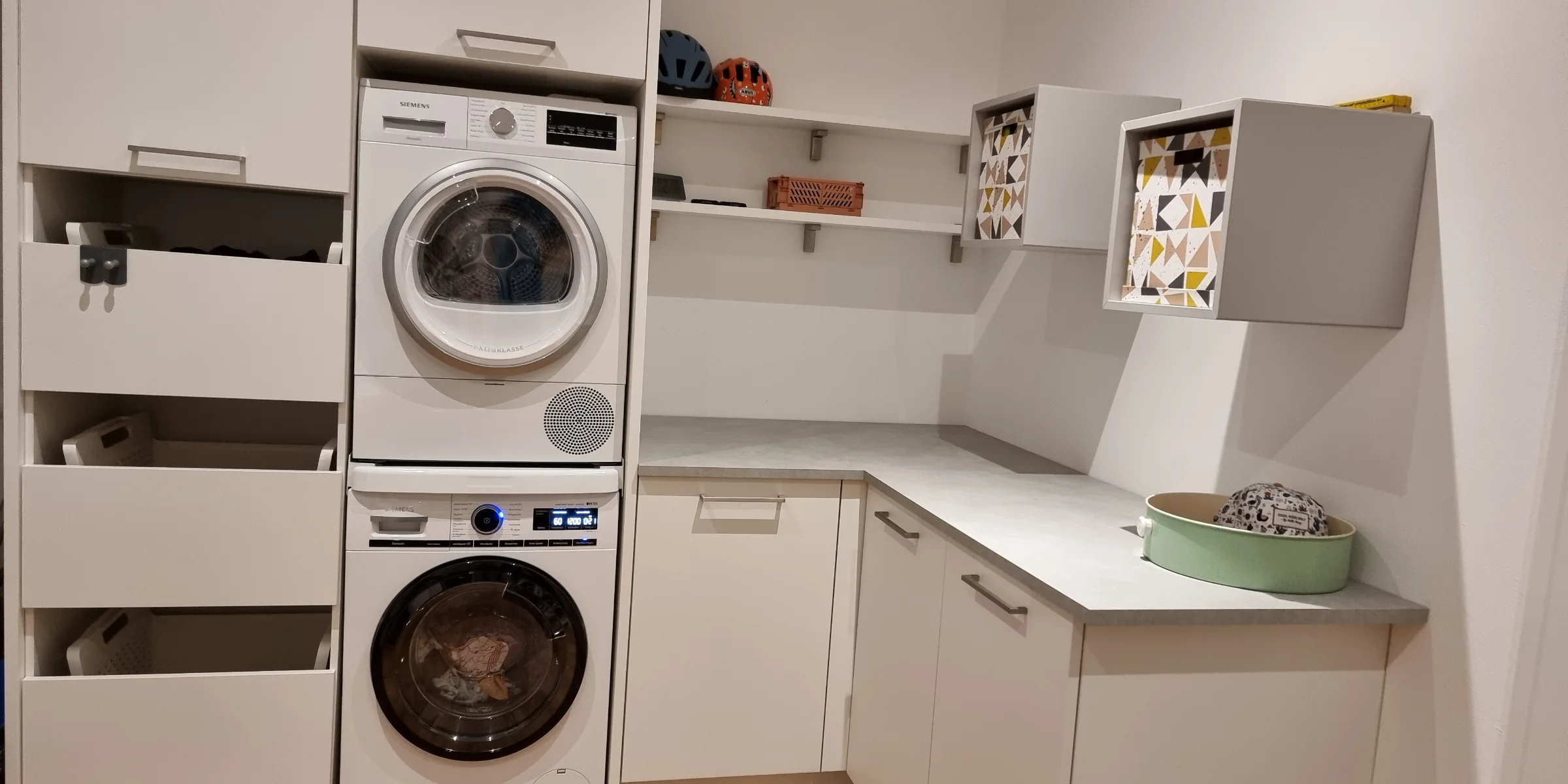 Une buanderie moderne avec machine à laver et rangements de Nolte Utility Rooms.