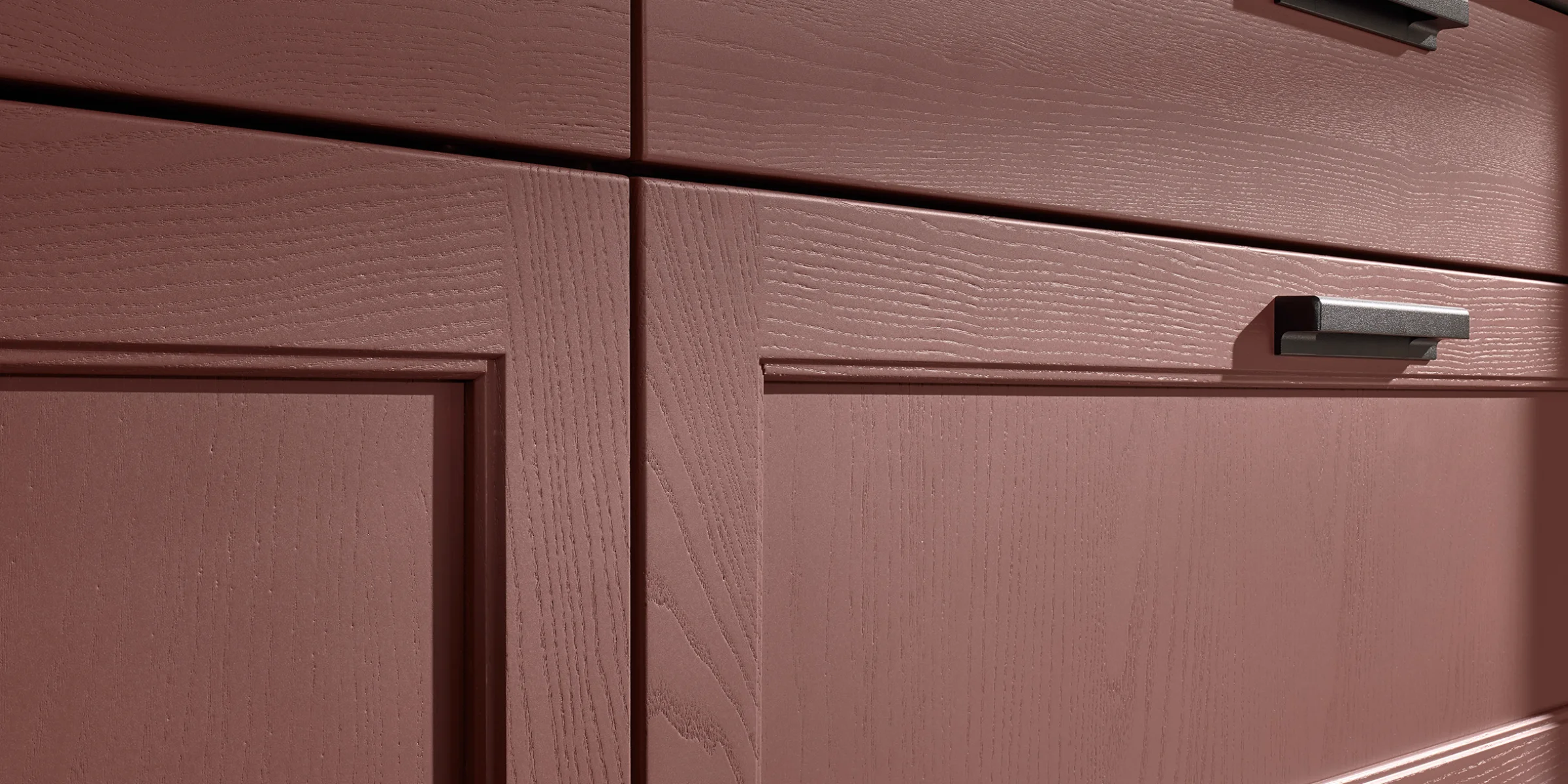 Rote Küchenschränke mit Holzstruktur und modernen Griffen in einem eleganten Design von Nolte Küchen.