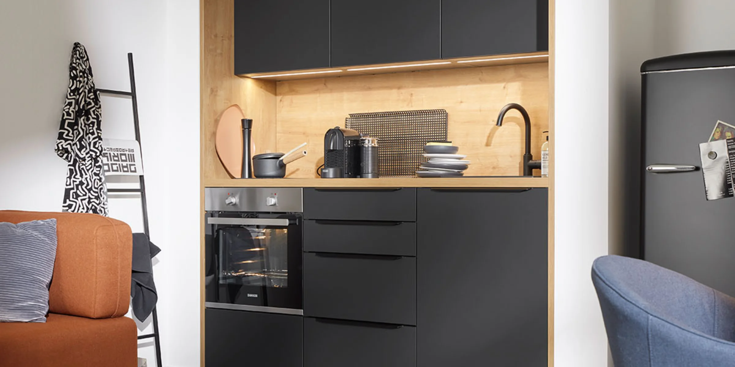 Cucina moderna con armadi neri e dettagli in legno di Nolte Kitchen.