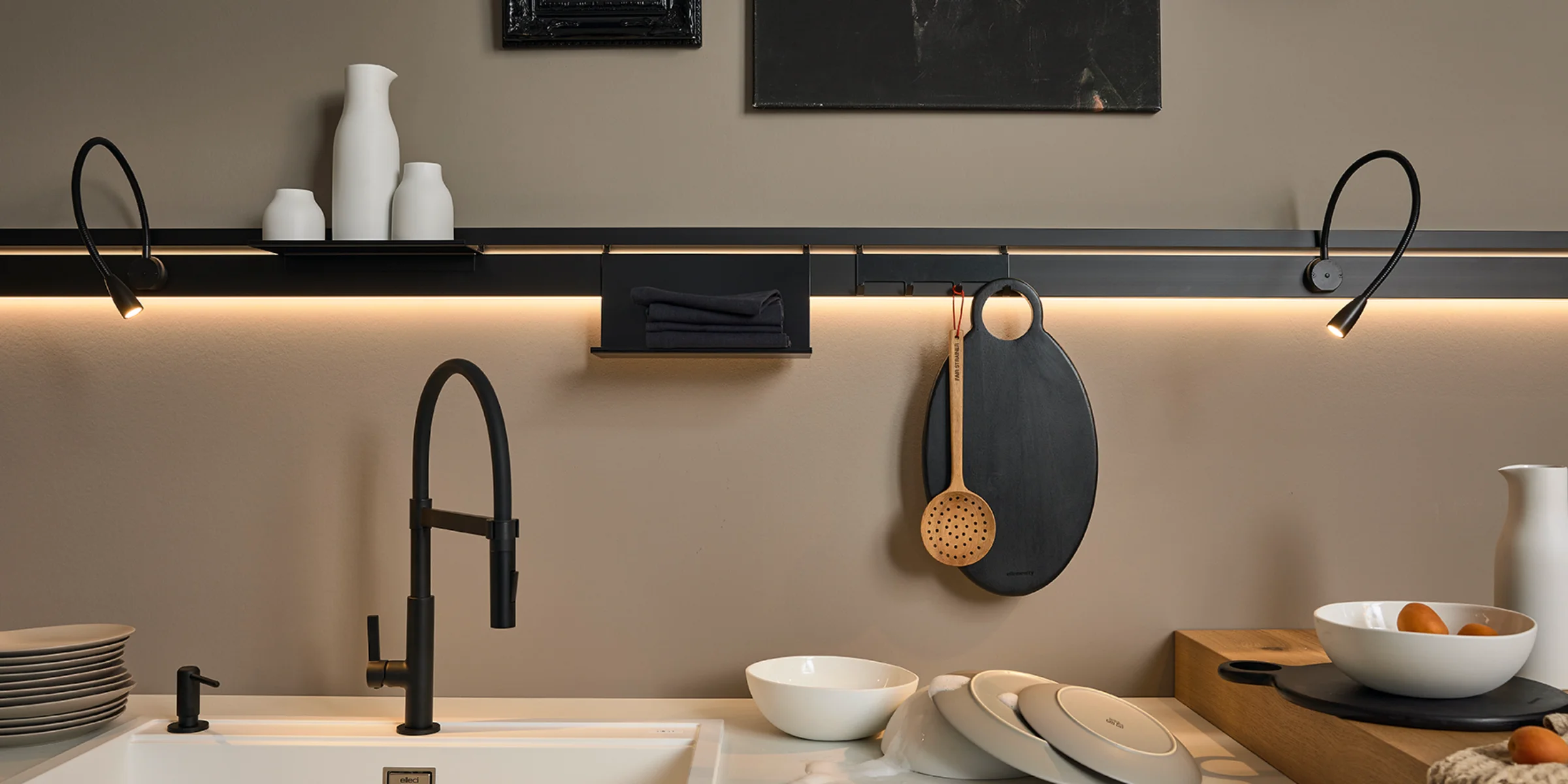 Eine moderne Küche mit schwarzem Wasserhahn und dekorativen Elementen, gestaltet von Nolte Küchen.