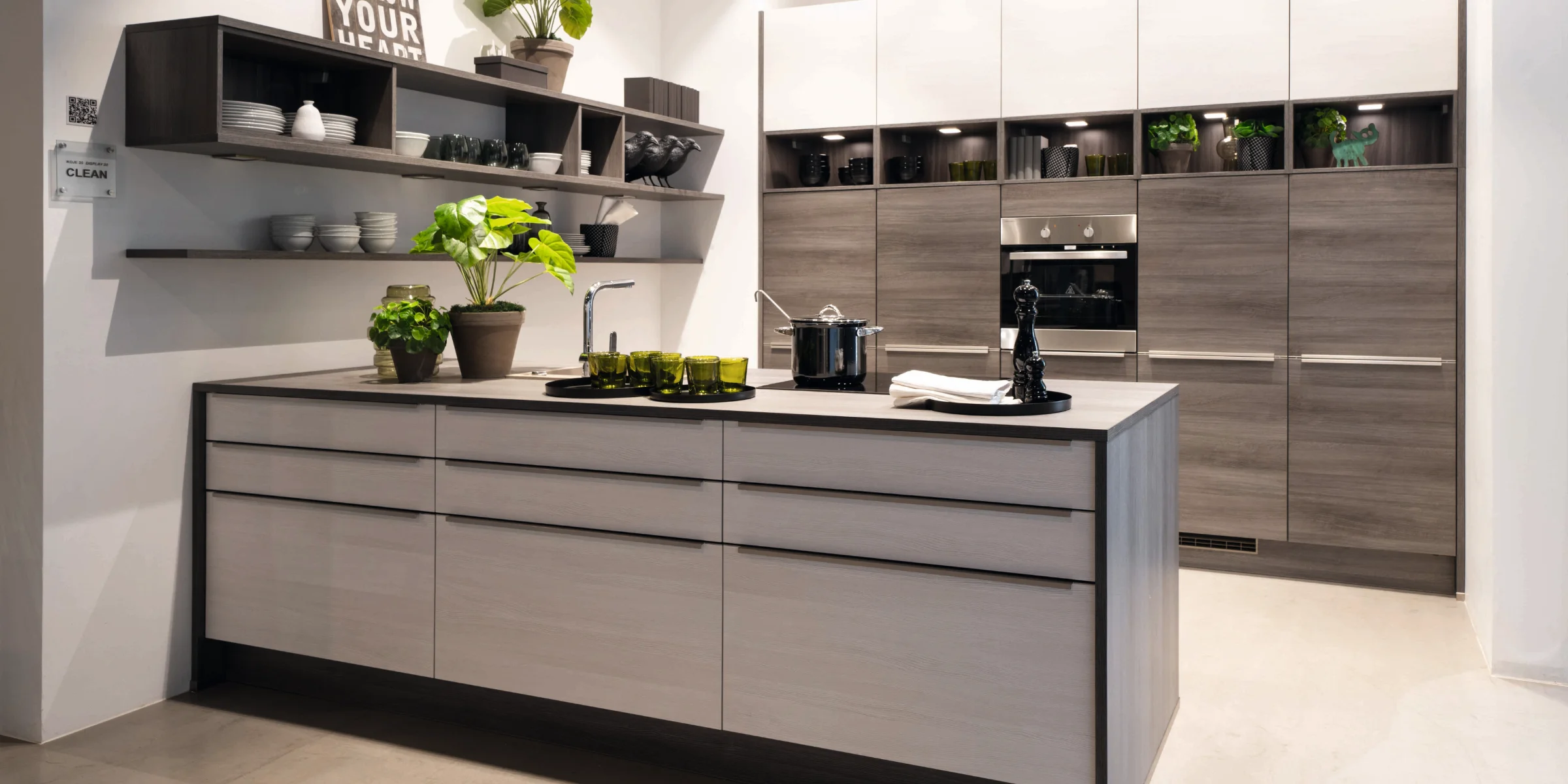 A modern kitchen with plants and gray cabinets. Express Küchen.