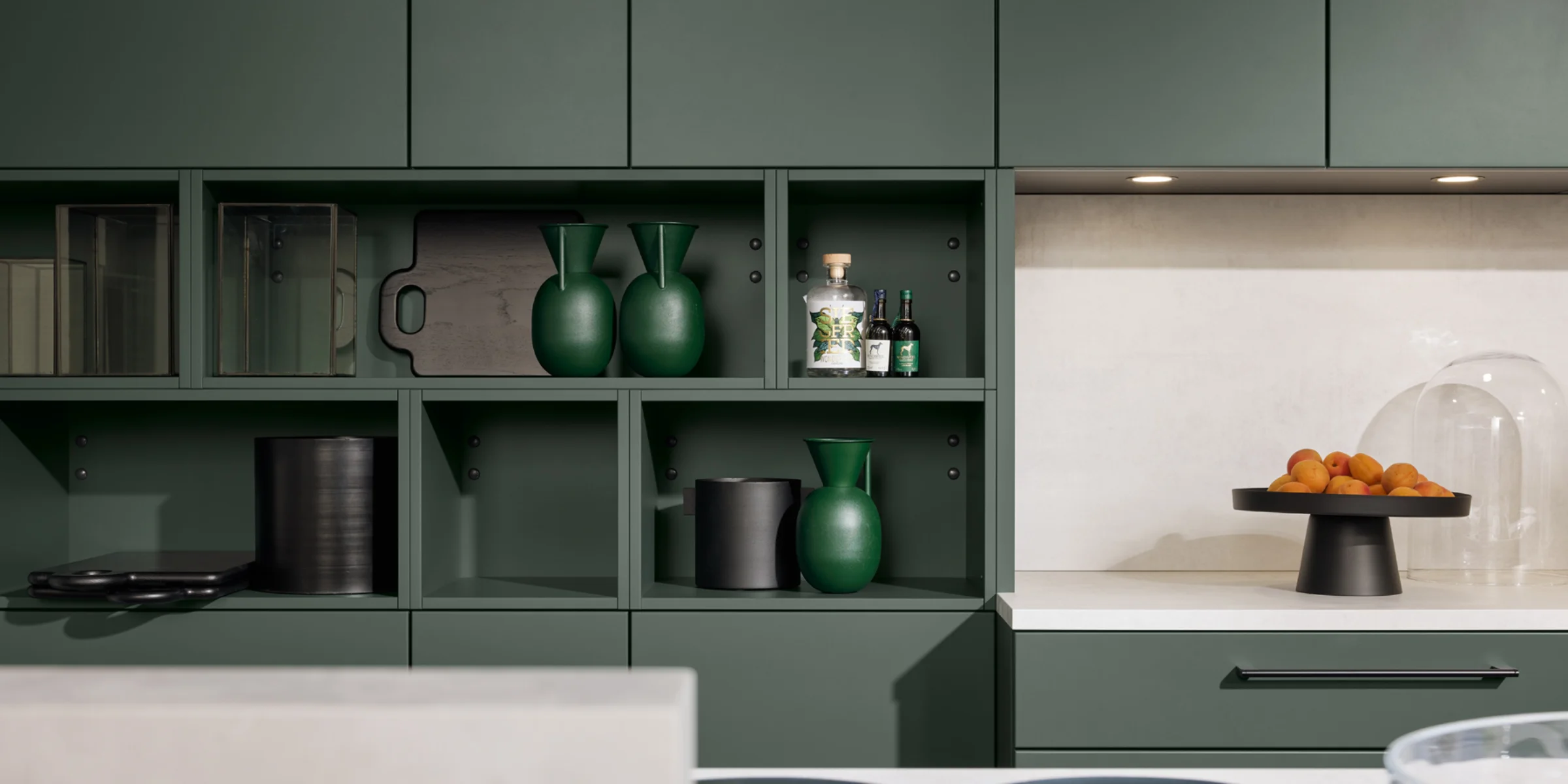 Eine moderne Küche mit grünen Schränken und Dekor, gestaltet von Nolte Küchen.