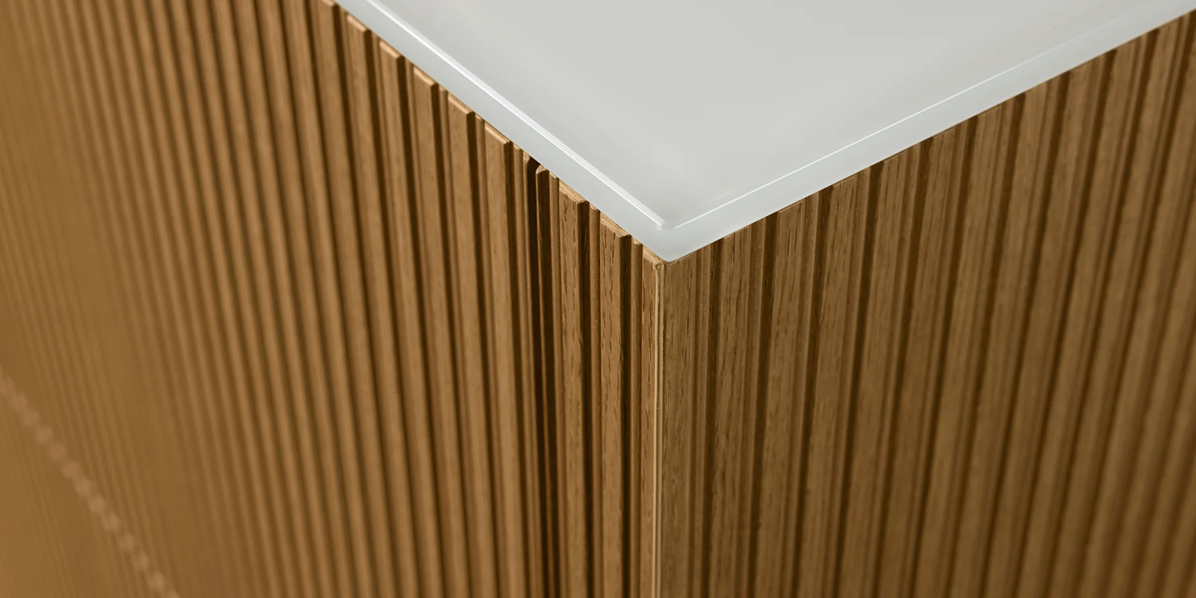 Ein hölzerner Schrank mit geriffelter Oberfläche und weißer Platte, Teil von Nolte Living.