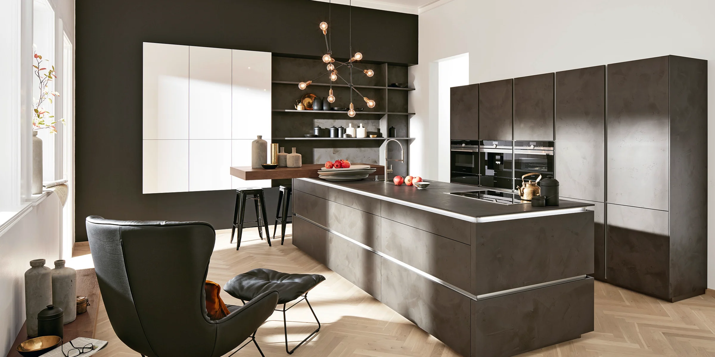 Eine moderne Küche mit Kochinsel und Designerstuhl, gestaltet von Nolte Küchen.