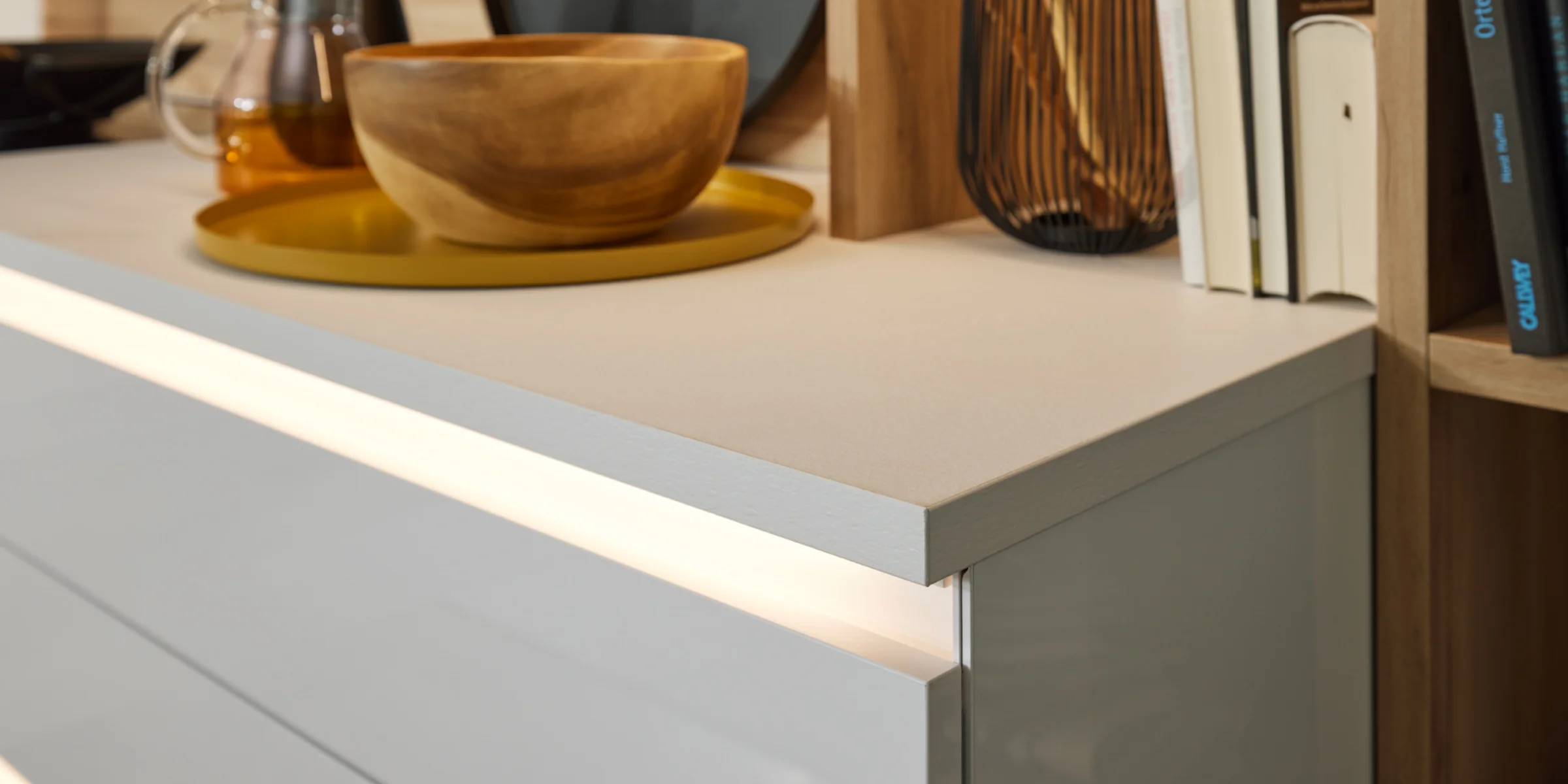 Eine moderne Küchentheke mit Holzschale und Kochutensilien, Nolte Küchen.