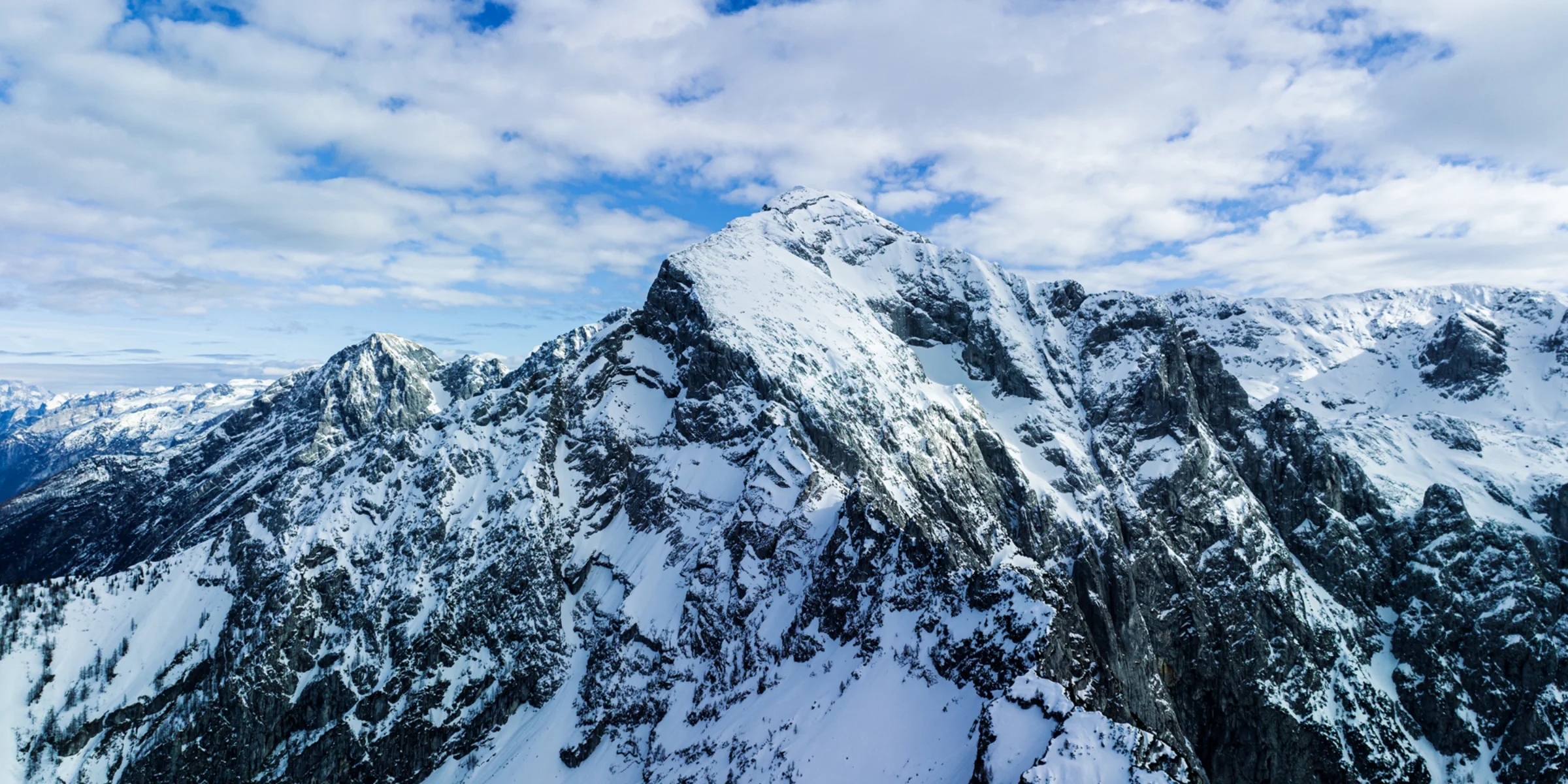 Verschneite Berglandschaft unter blauem Himmel.