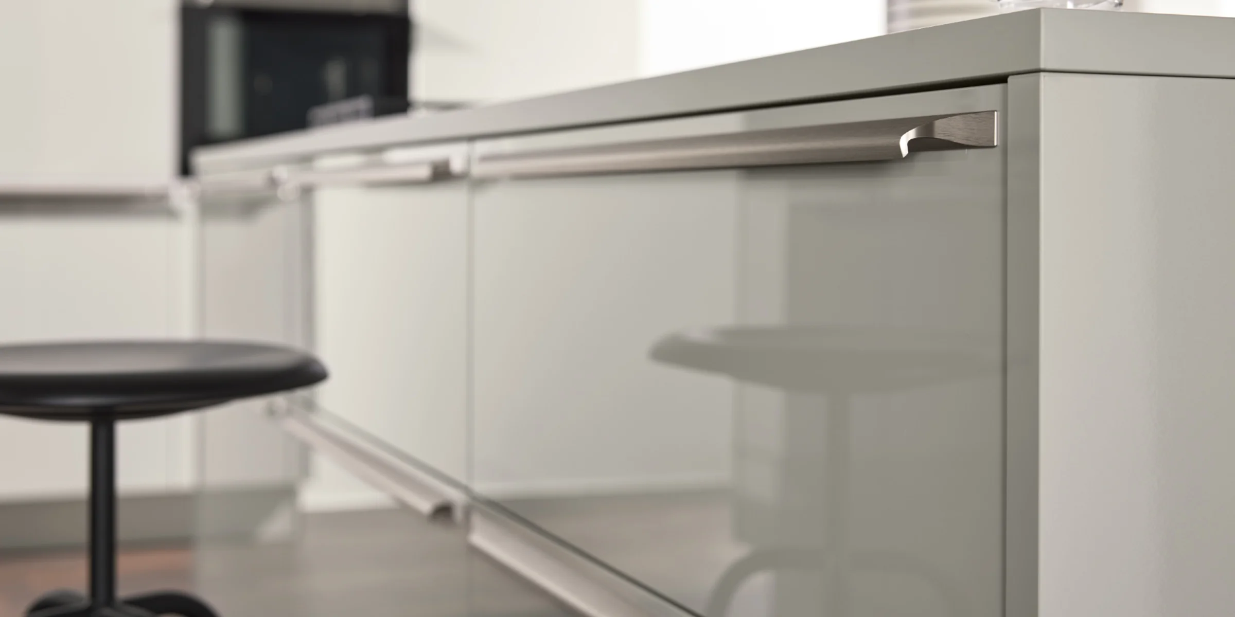 Eine moderne Küche mit glänzenden Oberflächen und einem Barhocker, Nolte Küchen.