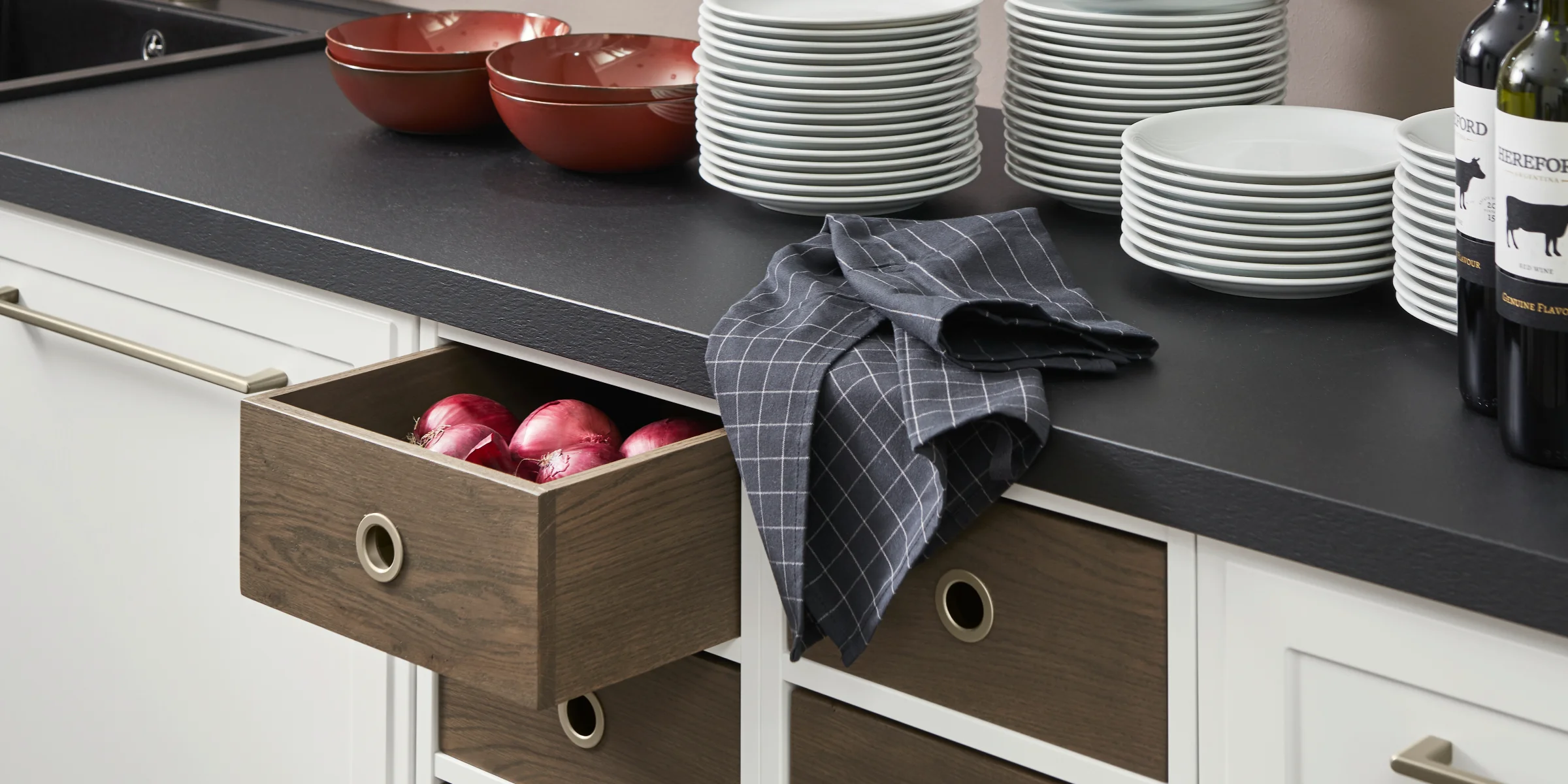 Eine moderne Küche mit Geschirr und Obstschublade, gestaltet von Nolte Küchen.