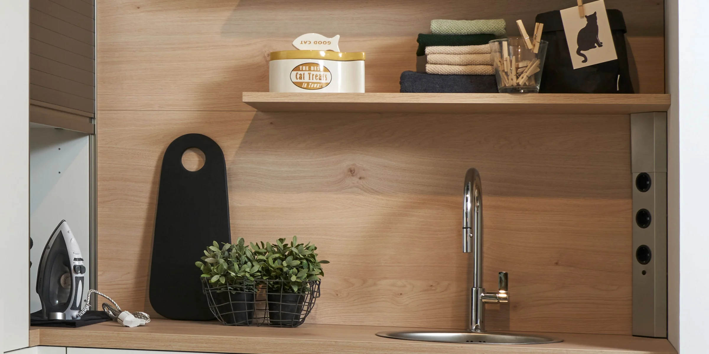 Eine moderne Küche mit Holzregalen und Spüle, dekoriert mit Pflanzen und Accessoires. Nolte Küchen.