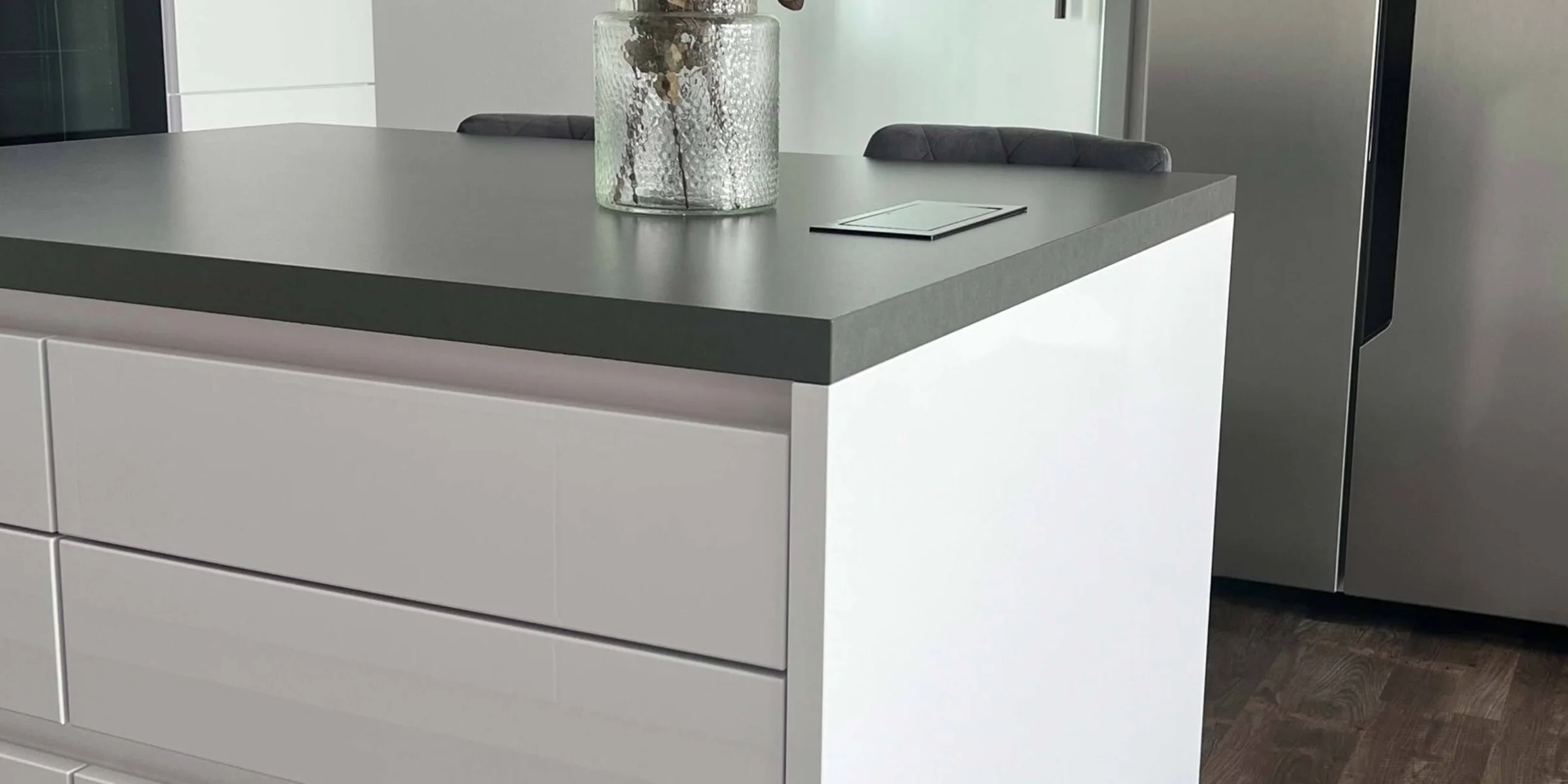 Eine moderne Küche mit einem weißen Inselblock und Edelstahlgeräten, Nolte Küchen.