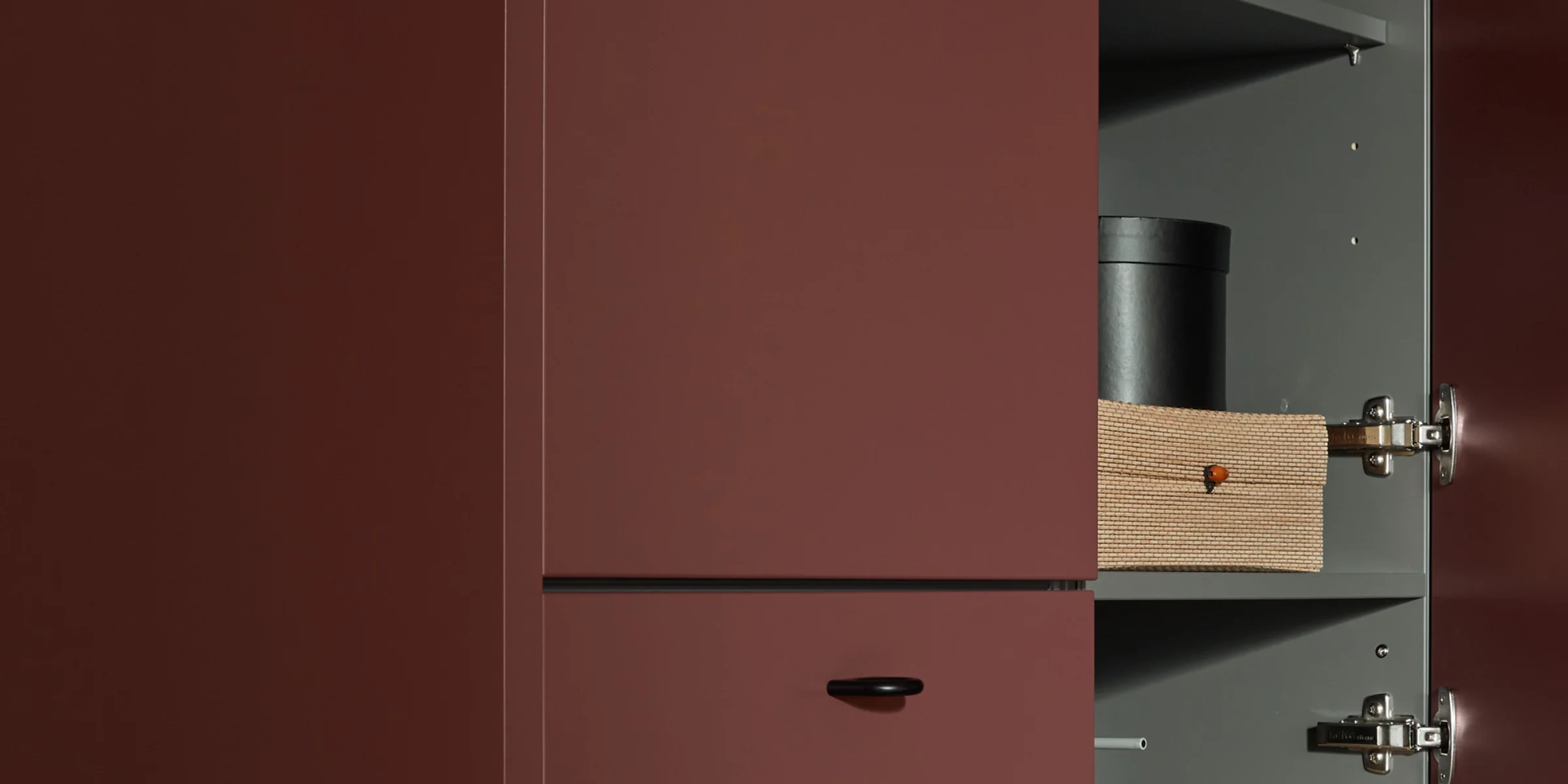 Ein stilvoller, offener Küchenschrank mit roten Türen und modernen Aufbewahrungsboxen. Nolte Küchen.