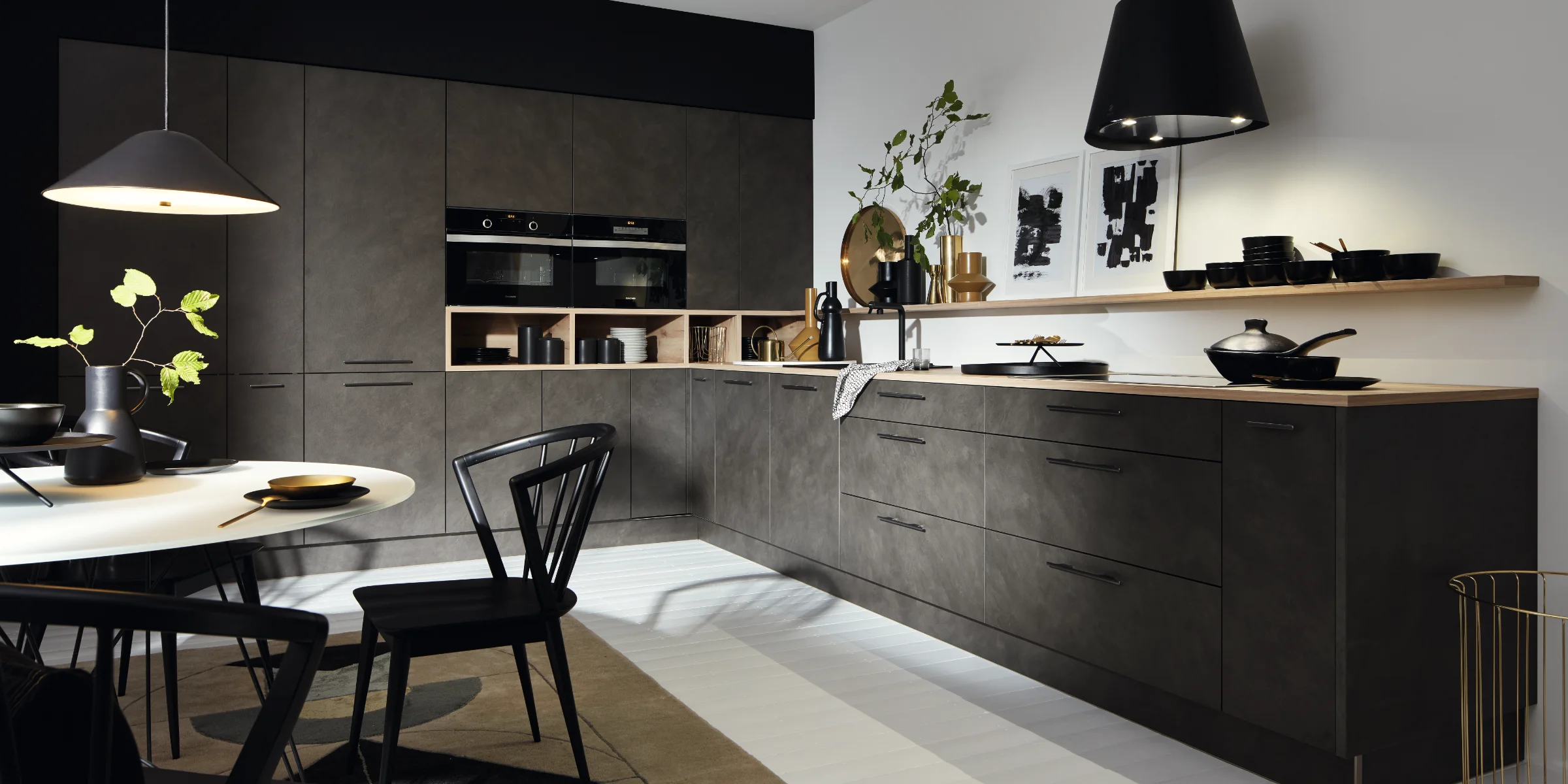 Moderne Küche mit dunklen Schränken, Esstisch und Dekorationen, gestaltet von Nolte Küchen.
