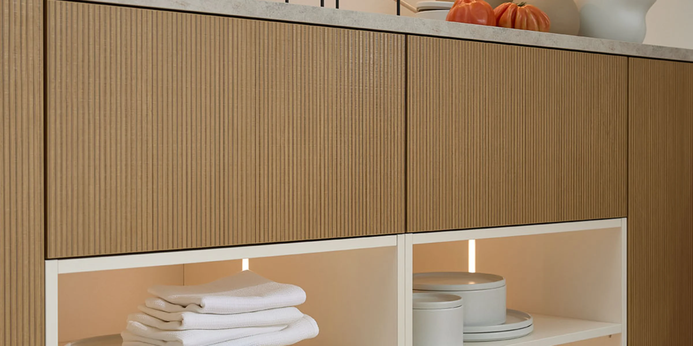 Ein modernes Wohnmöbel mit Geschirr und Deko-Elementen im Regal, präsentiert von Nolte Living.