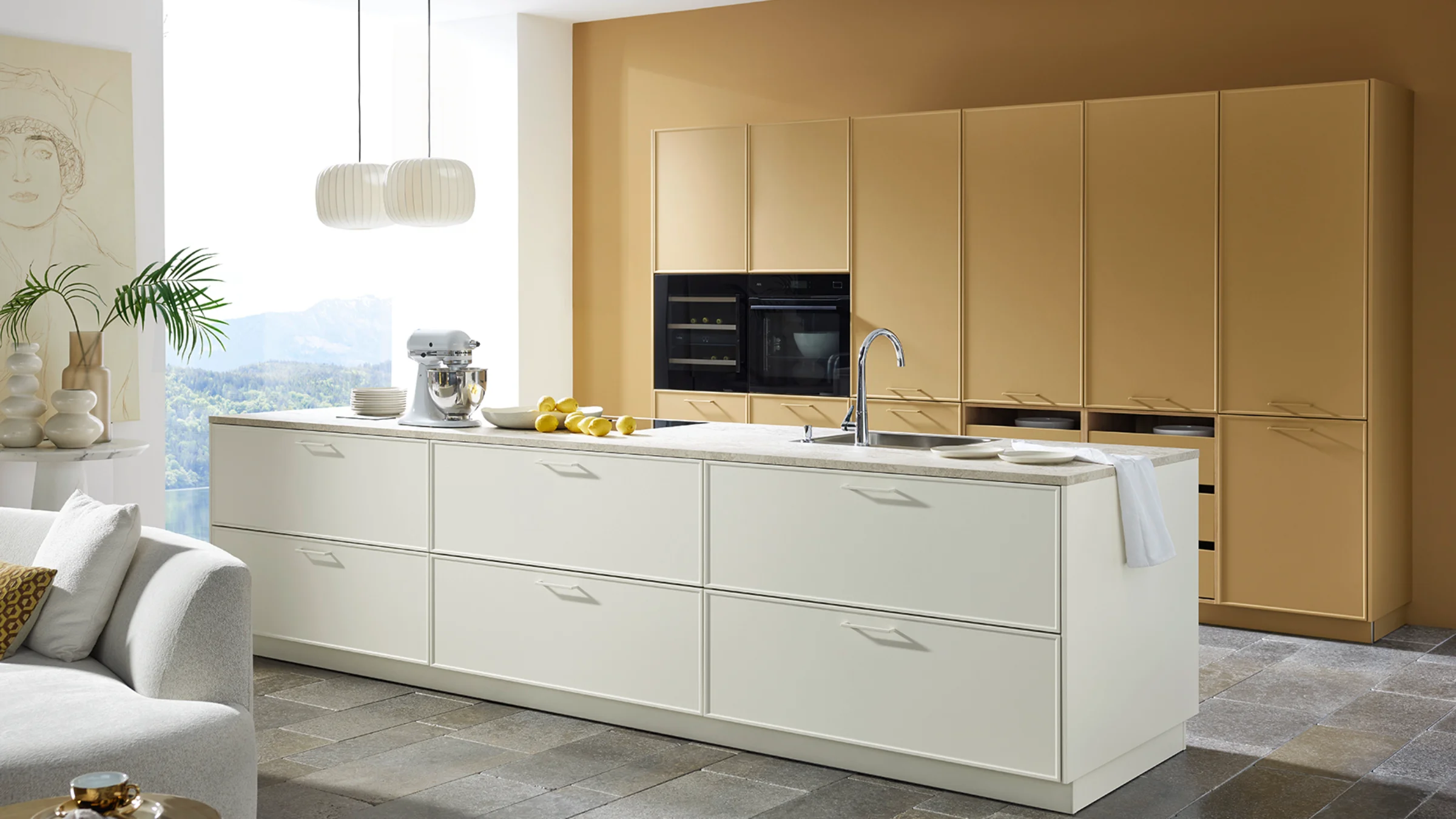 Eine moderne Küche mit Insel und beige Schränken. Nolte Küchen.