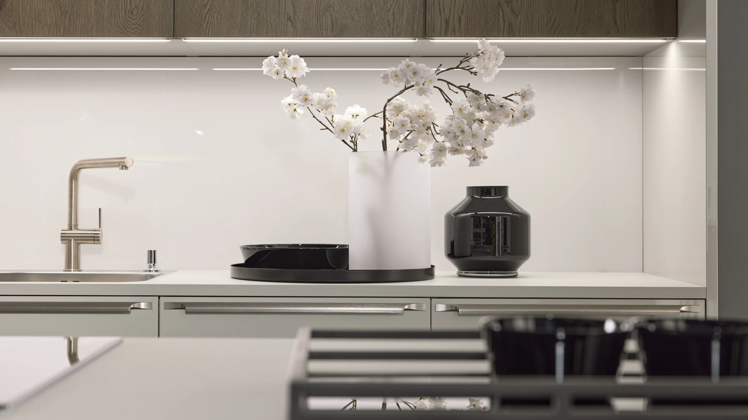 Eine moderne Küchentheke mit Blumendekor und stilvollen Armaturen, Nolte Küchen.