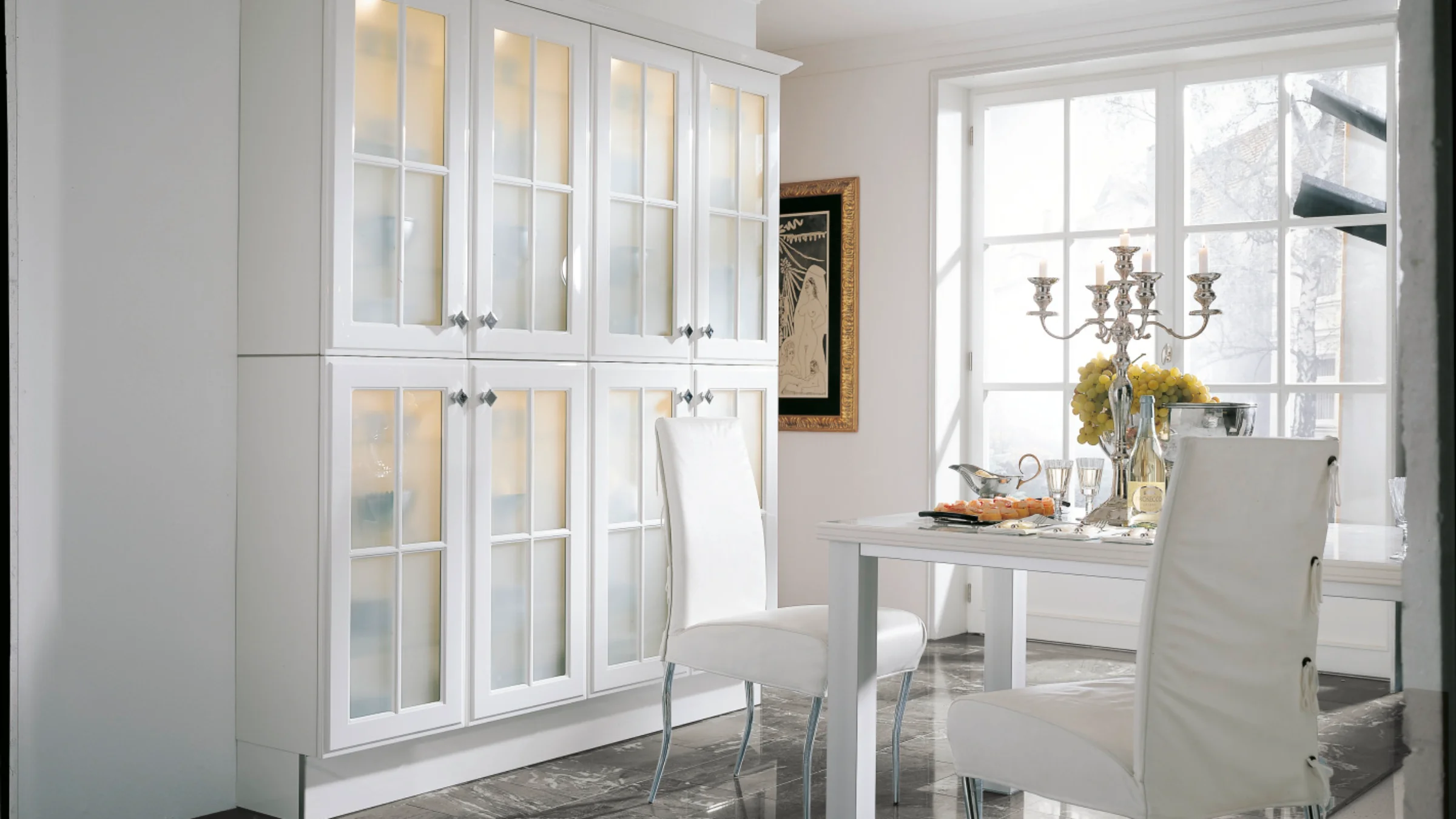 Ein stilvoller Essbereich mit weißen Möbeln und Glastüren vermittelt Eleganz, ergänzt durch Nolte Living.