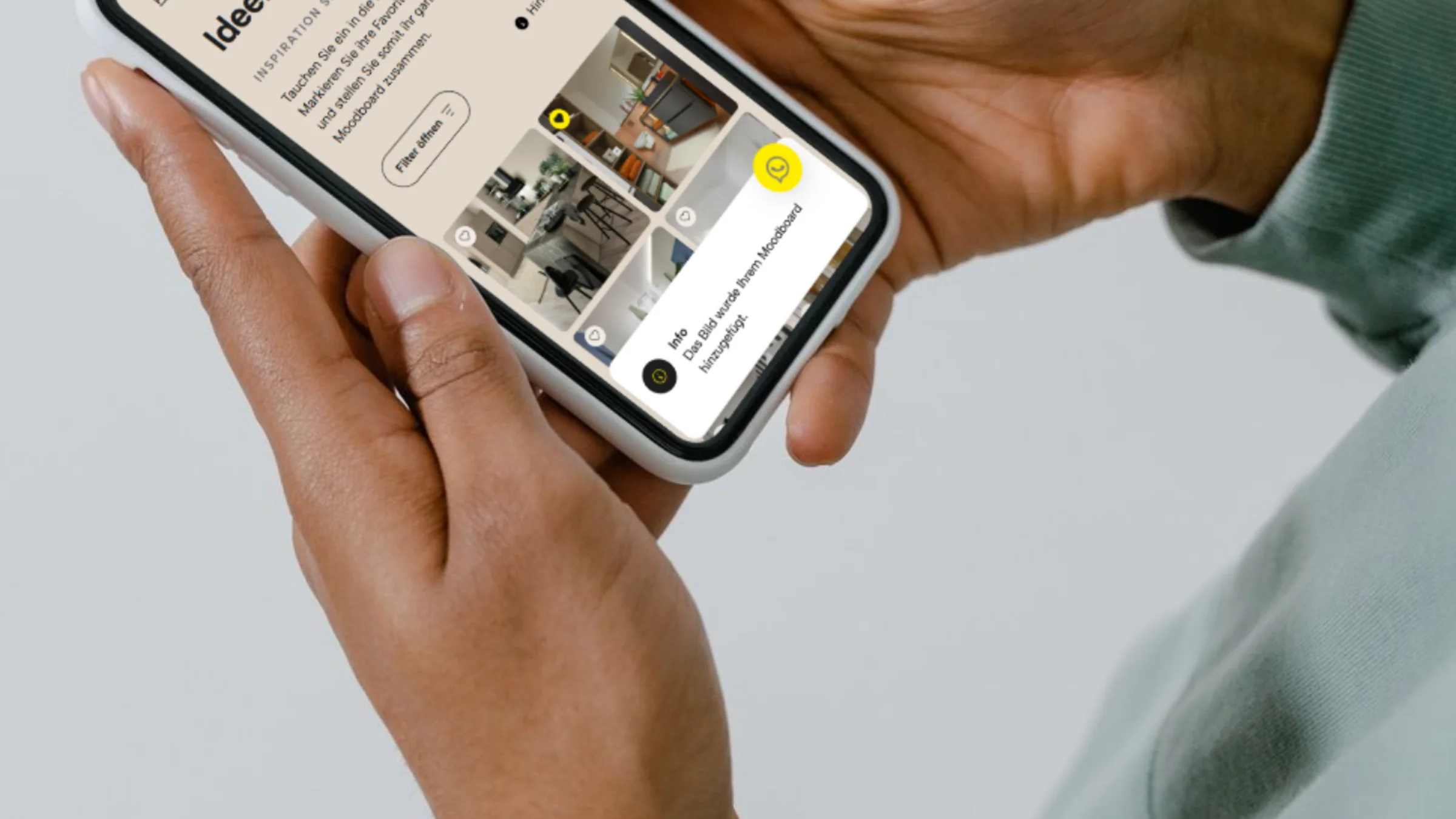 Eine Person hält ein Smartphone mit einer Website über Innenarchitektur.