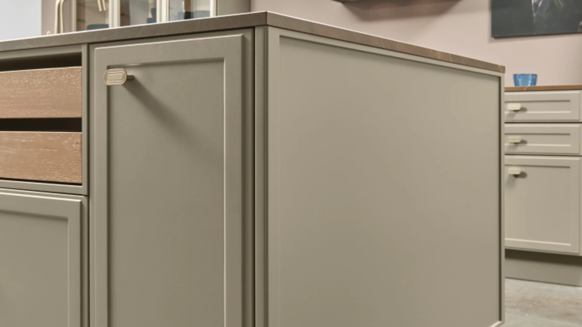 Eine moderne Küche mit Kochinsel und Schränken in Beige, gestaltet von Nolte Küchen.
