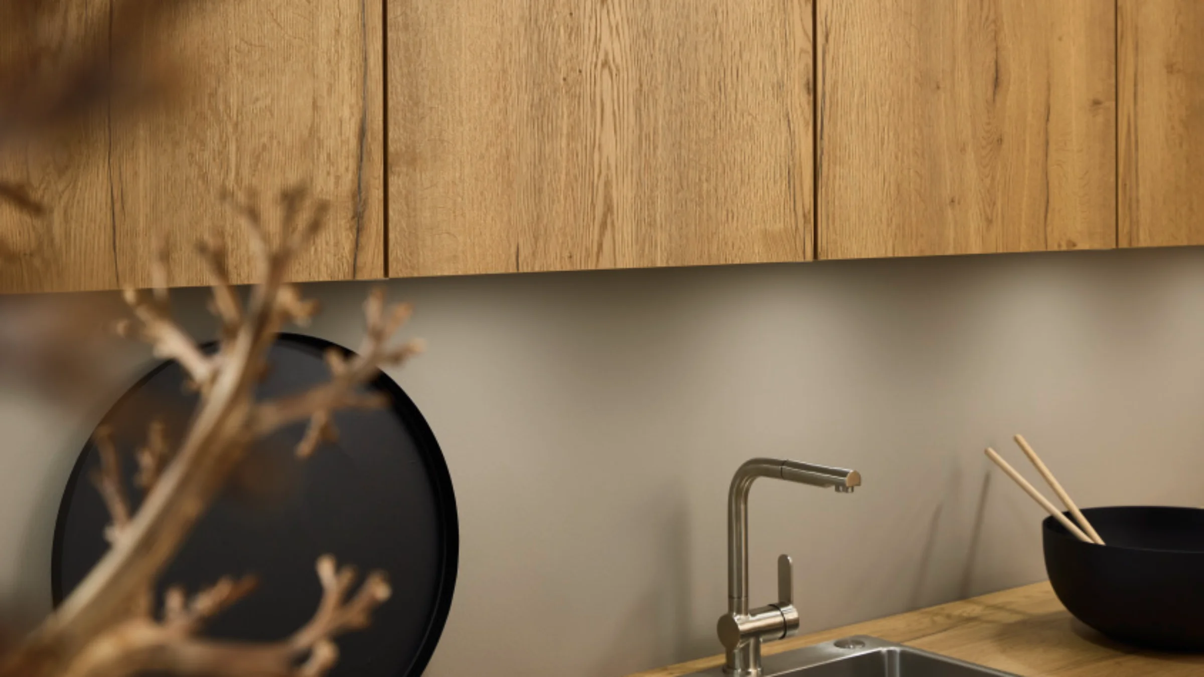 Eine moderne Küche mit Holzakzenten und Edelstahlspüle, gestaltet von Nolte Küchen.