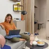 Eine Frau sitzt mit einem Laptop auf einem Sofa in einem modernen Wohnzimmer. Nolte Living.