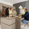 Eine moderne Küche mit vier Personen beim gemeinsamen Kochen. Nolte Küchen.