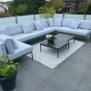 Eine moderne Terrasse mit grauem Loungesofa und Tisch, umgeben von Pflanzen.
