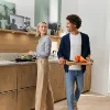 Nowoczesna kuchnia z drewnianymi frontami, w której gotuje para, prezentowana przez Nolte Kitchen.