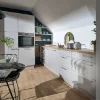 Moderne Küche mit weißen Schränken und Holzarbeitsplatte unter Dachschräge, Nolte Küchen.