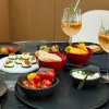 Ein stilvoll gedeckter Tisch mit Snacks und Getränken in einem modernen Ambiente von Nolte Küchen.