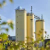 Drei gelbe Silo-Türme einer Fabrik mit dem Schriftzug "nolte küchen" unter blauem Himmel.