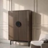 Ein eleganter Schrank steht neben einem beigen Sessel, Nolte Living.