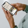 Eine Person hält ein Smartphone mit einer Website über Innenarchitektur.