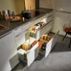 Eine moderne Küche mit offenen Schubladen und Kochutensilien auf der Arbeitsplatte von Nolte Küchen.