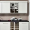 Una cocina moderna con armarios blancos y encimera oscura, presentada por Nolte Cocina.