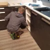 Eine Person arbeitet in einer modernen Küche mit dunklen Schränken. Nolte Küchen.