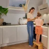Eine Frau und ein Kind kochen gemeinsam in einer modernen Nolte Küchen-Einbauküche.