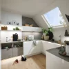 Eine moderne Küche mit weißen Schränken und Dachfenster, gestaltet von Nolte Küchen.