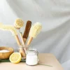 Natural cleaning brushes, half a lemon, and salt on a table.
