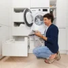 Ein Mann nutzt eine Waschmaschine in einem modernen Nolte Hauswirtschaftsraum.