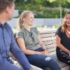 Three people smiling on an outdoor bench, Nolte Kitchen.