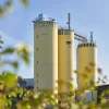 Drei große gelbe Silos mit der Aufschrift "Nolte Küchen" stehen vor einem klaren Himmel.