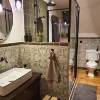 Un elegante baño con ducha y lavabo, decorado con plantas y azulejos. Nolte SPA.